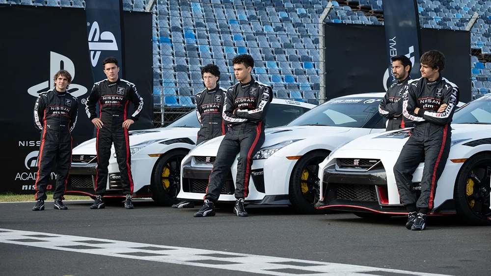 Gran turismo drivers in black, white and red racing suits leaning on white racing GT-Rs.